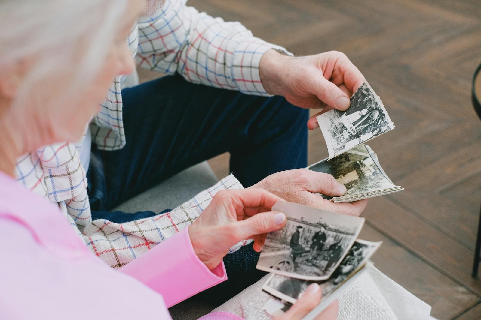 An elderly couple looks through old photo albums together — a powerful tool in memory care at home.